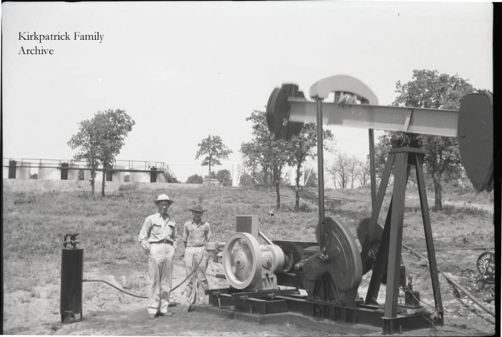Two unidentified oil pump operators at a location possibly associated with the Kirkpatrick Oil Company.